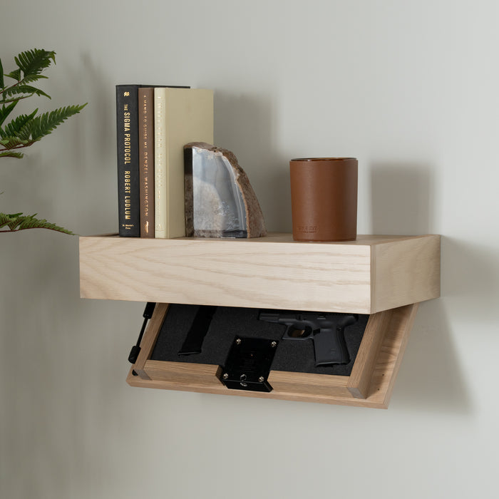 Murphy Door® wooden shelf with concealed gun compartment, displaying books and decorative items while hiding a handgun in the secret drawer.