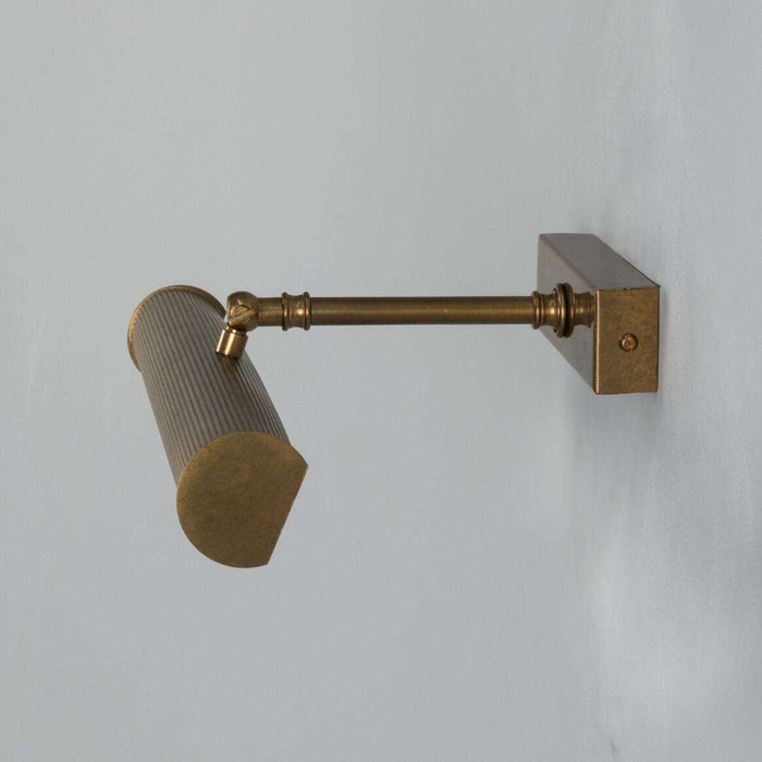 Cambridge Adjustable Brass Picture Light in Antique Brass illuminating framed artwork