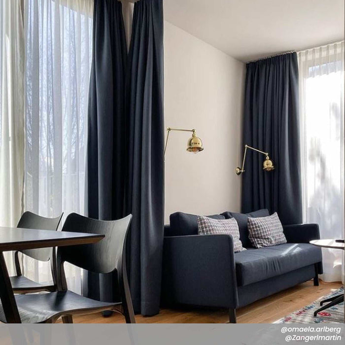 Dale Adjustable Wall Light with three pivot points highlighting artwork and bookcases in warm traditional design