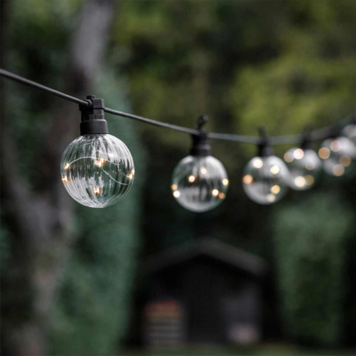 Festoon Linear Lights with 10 warm white bulbs hanging outdoors for cozy ambient lighting