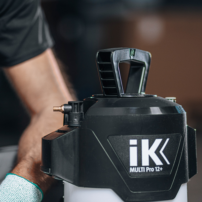 Black and white pressure washer with 'iK' branding held by a person.