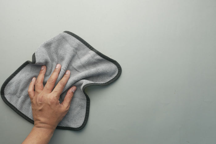 Gray microfiber cleaning cloth spread flat on a light surface