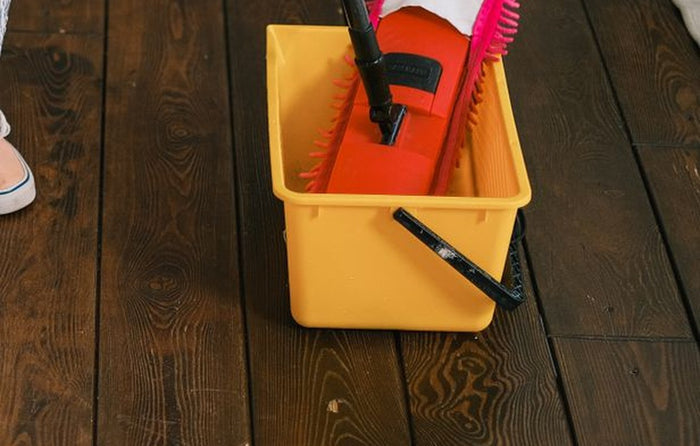 Close view of the chenille mop pad resting in the rectangular bucket