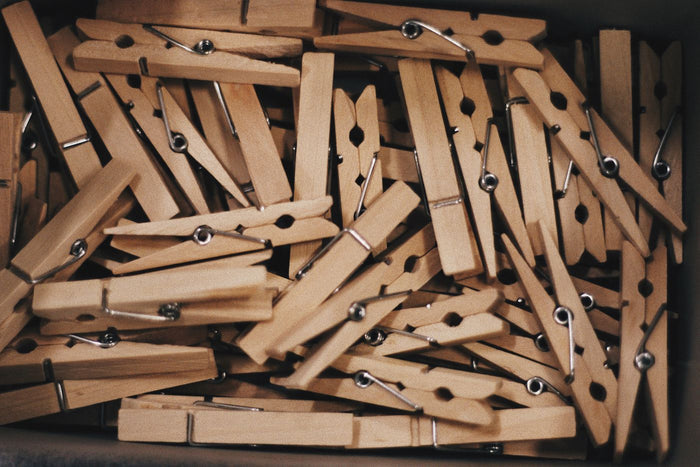 Box filled with natural wooden clothespins with metal springs