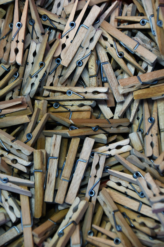 Pile of natural wooden clothespins viewed from above