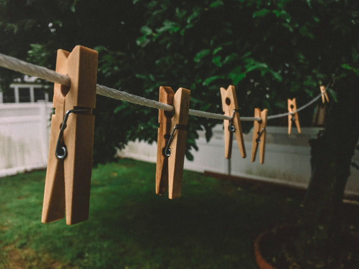 Wooden clothespins on a white rope clothesline outdoors