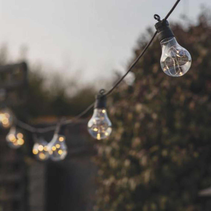 Solar Festoon 10 Bulb classic black solar-powered outdoor string lights illuminating a garden patio
